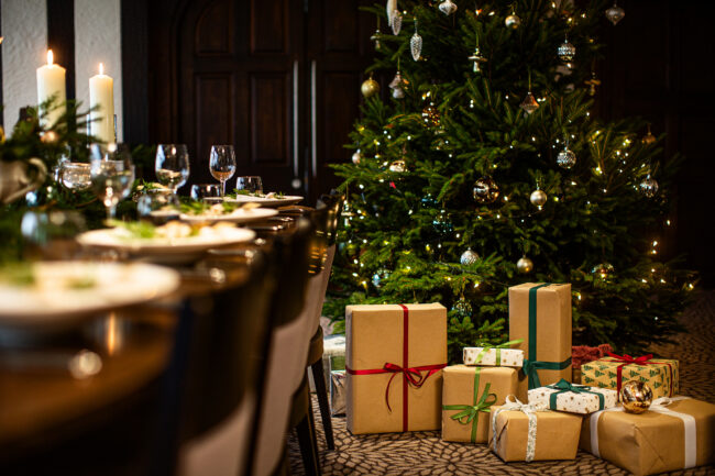 Christmas at Hogarths Stone Manor. Parcels piled up under a Christmas tree - styled design